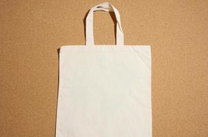 bolsa de lona beige ecológica de lino vacía para la marca sobre fondo marrón. bolsa transparente reutilizable para comestibles, maqueta. endecha plana