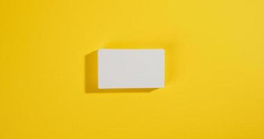 a stack of white rectangular business cards on a yellow background, company branding, address photo