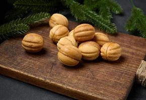 baked dessert nuts with condensed milk on a wooden board, top view photo