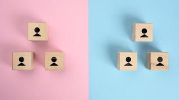 wooden blocks with figures on a pink blue background, hierarchical organizational structure of management photo