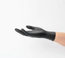 female hand in a black latex glove on a white background photo