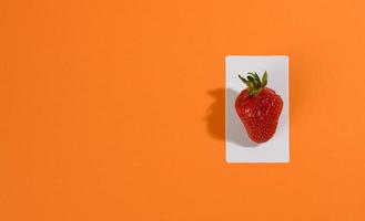 red ripe strawberries on an orange background