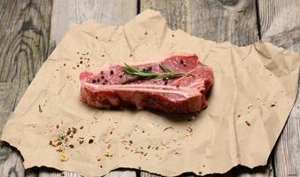fresh raw piece of beef meat, striploin steak on a paper background, top view. Marbled piece of meat