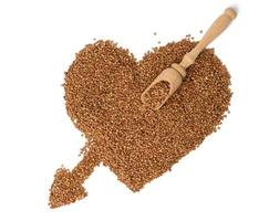 montón de granos de trigo sarraceno sin cocer, vista superior. grañones dispuestos en forma de corazón