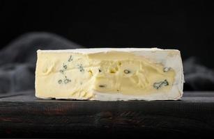 queso azul bergader sobre una tabla de madera marrón, delicioso aperitivo foto