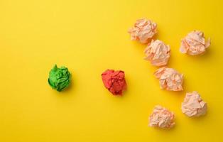 crumpled sheets of colored paper on a yellow background. Solution concept, brainstorming photo