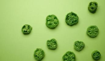 green pieces of loofah on a green background, top view photo