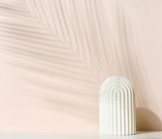 podium with white arche to showcase cosmetics, products and other merchandise. Shadow palm leaf photo
