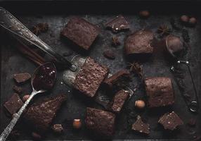 pieces of baked chocolate brownie pie in a metal baking sheet on a black table photo