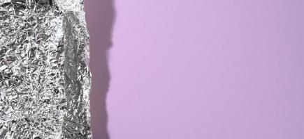 pedazo arrugado de lámina gris con sombra en púrpura, vista superior foto