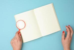 paper notebook with blank white sheets and a red magnifier on a blue background photo