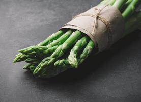 Fresh green asparagus sprouts on a wooden background. View from above photo