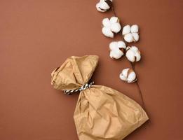 full brown paper disposable food bag on a beige background, concept of delivery and ordering, top view photo