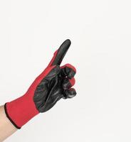 hand in a black-red textile work glove points with the index finger to the side on white photo