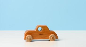 Coche de juguete de madera vintage para niños con ruedas sobre fondo blanco. foto