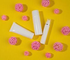 botella y tubos de plástico blancos vacíos para cosméticos sobre un fondo amarillo. envases para crema, gel, suero, publicidad y promoción de productos