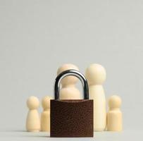 metal lock and a family of wooden figures on a gray background. Security concept, personal data photo
