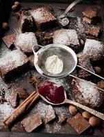baked square pieces of chocolate brownie sprinkled with powdered sugar on the table photo
