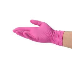 mano femenina en un guante de látex rosa sobre un fondo blanco foto