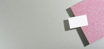 la tarjeta de presentación rectangular en blanco se encuentra sobre un moderno fondo gris hojas de papel con una sombra