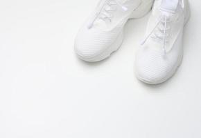 White textile sneakers on a white background, top view photo