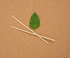 two wooden chopsticks on a brown background,  top view photo
