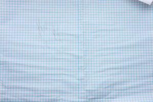 crumpled white paper texture in a cage, blue lines, school notebook photo