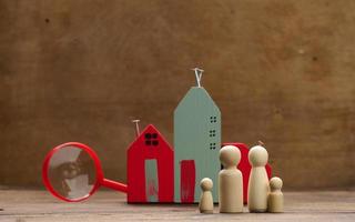 wooden family figurines, model house on a brown background. Real estate purchase, rental concept. Moving to new apartments photo