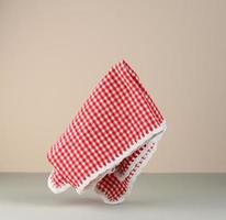 red and white checkered kitchen towel levitates on beige gray background photo