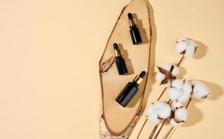 glass cosmetic brown bottles with a pipette on a beige background. Cosmetics SPA branding mockup, top view photo