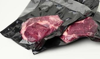 piece of fresh beef meat packed in a vacuum plastic bag, top view photo