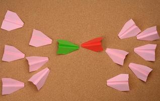 two large groups of paper airplanes on a brown background. Conflict of interest photo