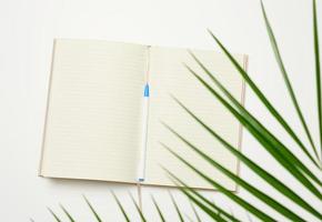 open notebook with blank white sheets on a white background, top view photo