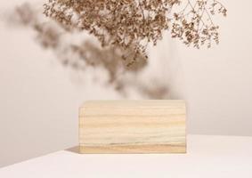 wooden podium to showcase cosmetics and other items, beige background with dry wildflowers and shadow photo