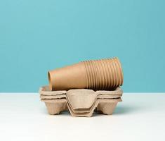 stack of paper disposable brown cups and stand on white table photo