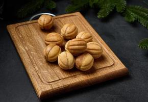 baked dessert nuts with condensed milk on a wooden board, top view photo
