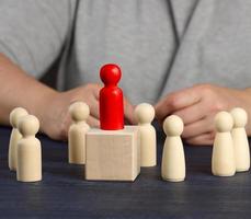 wooden red figurine chosen from the crowd. The concept of finding talented employees, managers, career growth. Staff recruitment photo