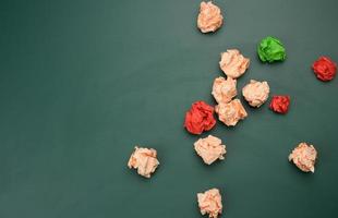 crumpled balls of paper on a green background, top view. Concept of finding innovative ideas, right solutions photo