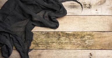 folded black gauze towel on a table made of old gray wooden boards photo