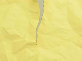 blank torn crumpled yellow sheet of paper on a gray background photo
