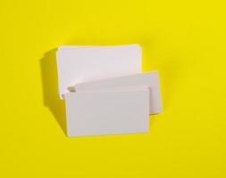 a stack of white rectangular business cards on a yellow background, company branding, address photo