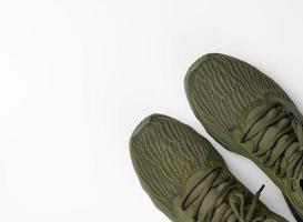 pair of green textile sneakers on a white background, top view. Shoes for sports, jogging photo