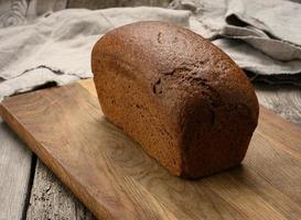 baked rectangular rye flour bread on brown board photo