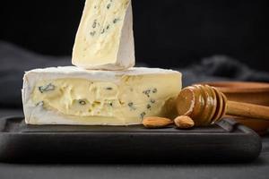 bergader blue cheese on a black wooden board, delicious snack photo