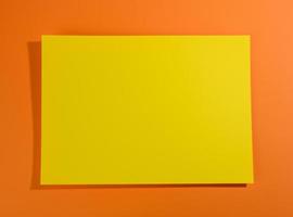 hoja de papel amarilla en blanco sobre fondo naranja con sombra