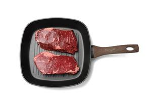 two raw pieces of beef in a black square grill pan, steaks isolated on white background photo