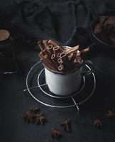 cinnamon sticks in an old metal mug on a black table. Aromatic spice photo