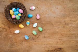 Colorful Easter Egg and nest on a rustic old wood background. Above view with copy space. photo