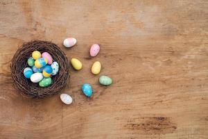 Colorful Easter Egg and nest on a rustic old wood background. Above view with copy space. photo