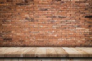 Empty wooden table top and red brick wall and rough crack background texture photo